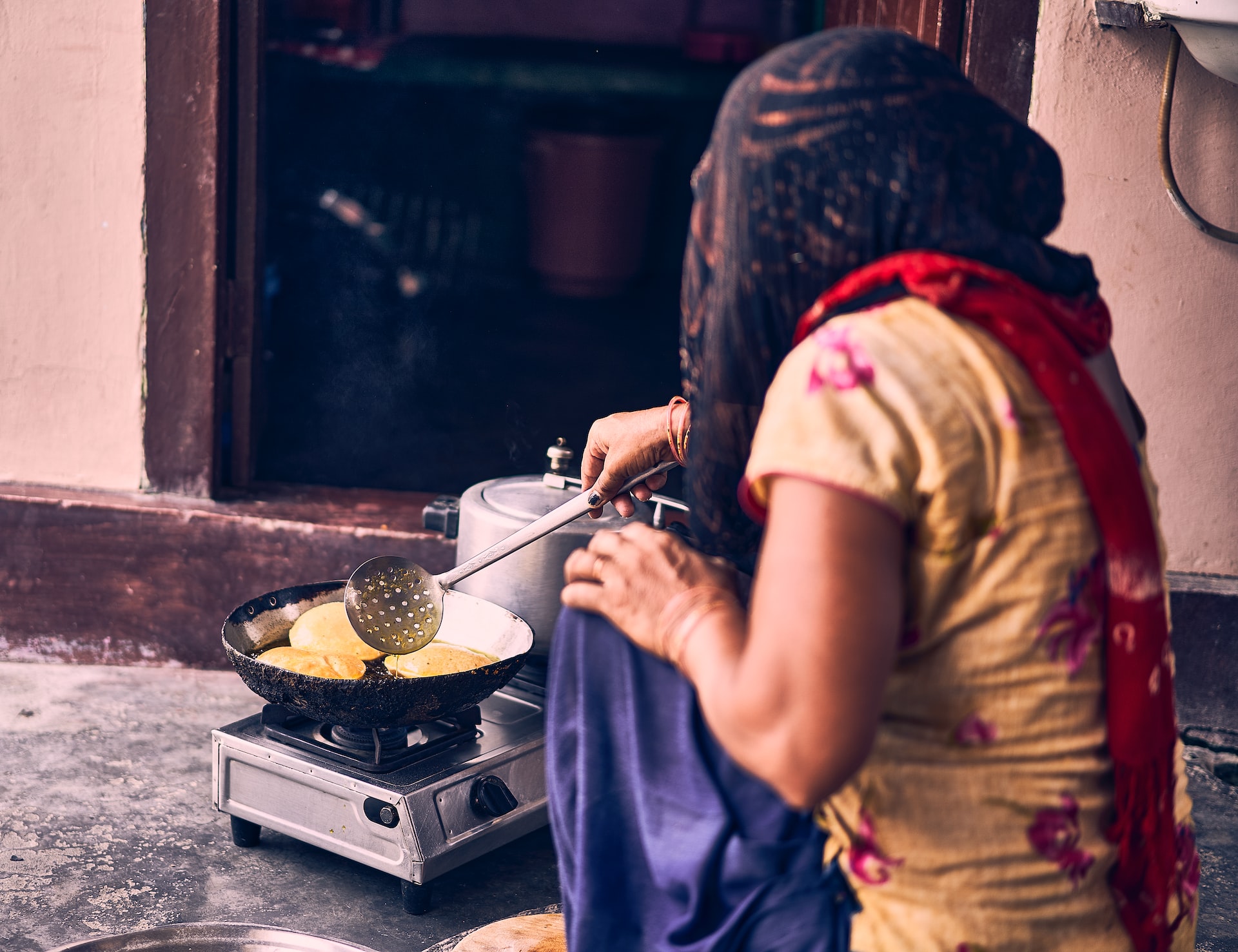 Woman cooking a puri. Photo: Ashwini Chaudhary / Unsplash