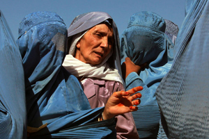 In Herat, Afghanistan, women line up to collect bags of split chick pea, wheat, and cooking oil being distributed by the UN World Food Programme (WFP). © UN Photo/Eric Kanalstein