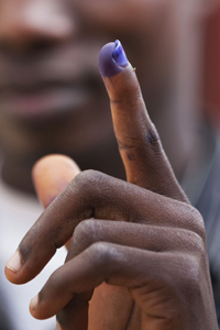 A Liberian holds up his ink-stained finger, proof of his having voted. © UN Photo/Staton Winter
