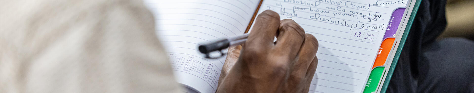 Tanzanian man writing on a notebook. Image: Imani Nsamila / UNU-WIDER